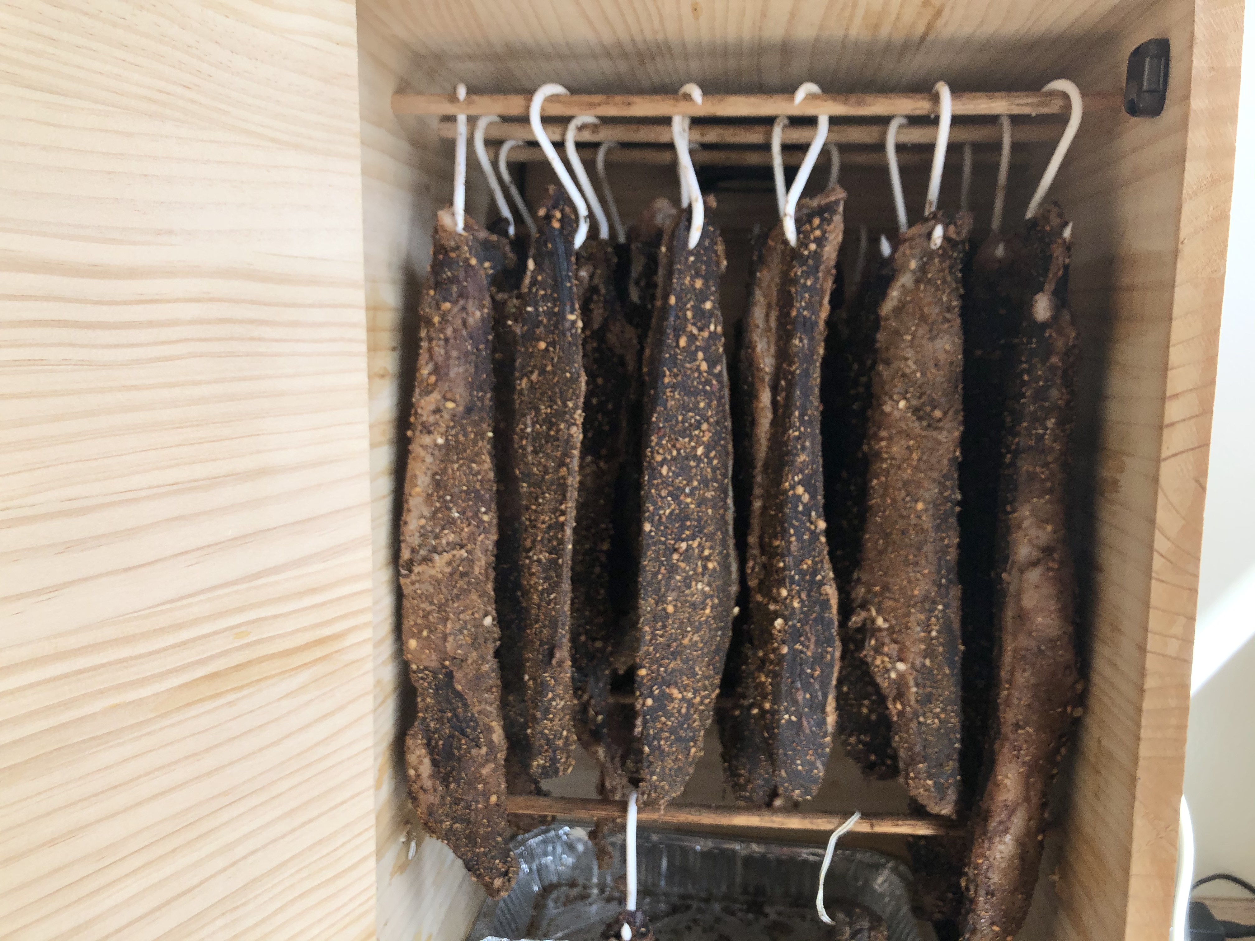 Biltong hanging on a drying rack at Zania Farm