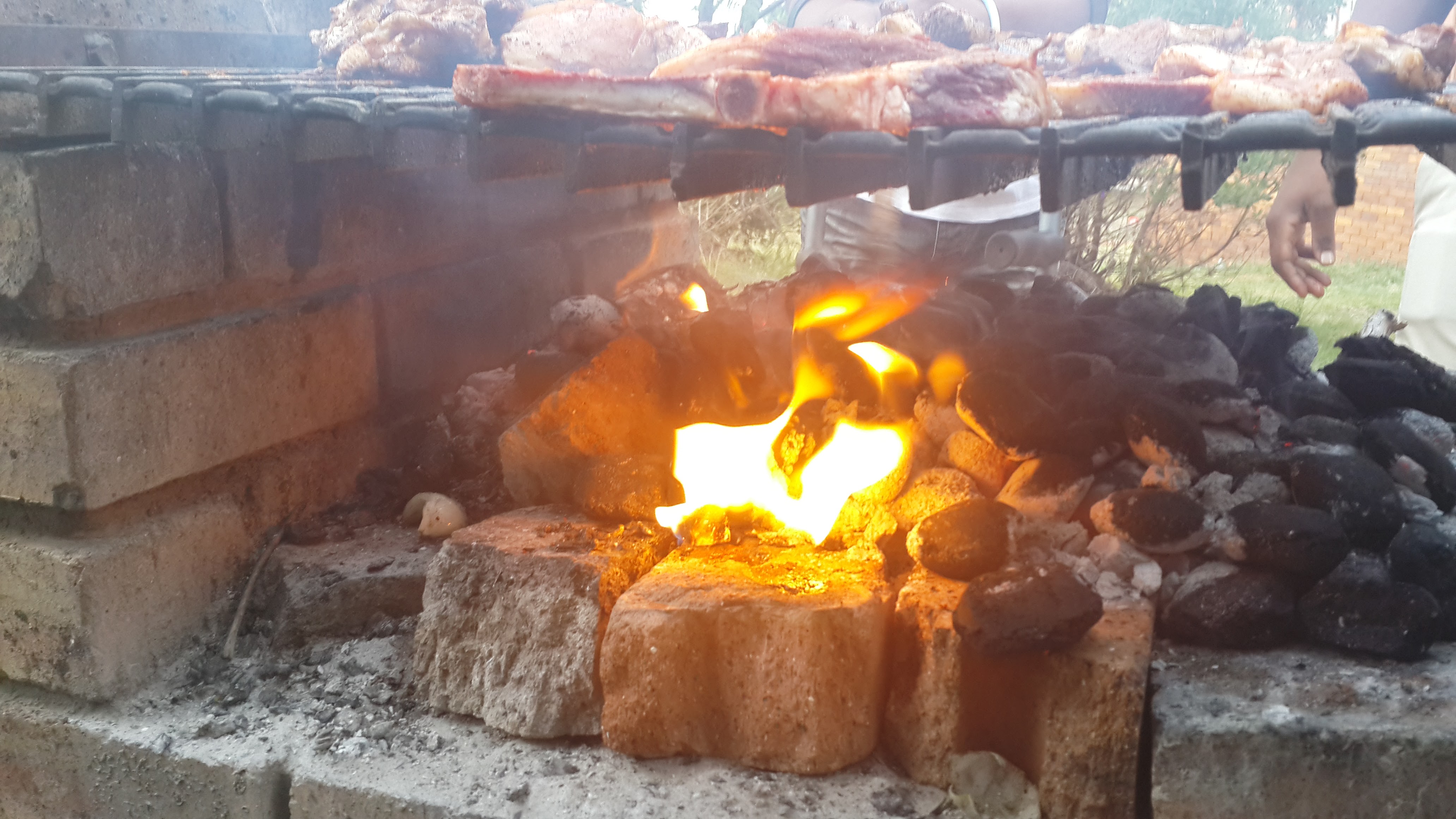 Food cooking over an open braai fire at Zania Farm
